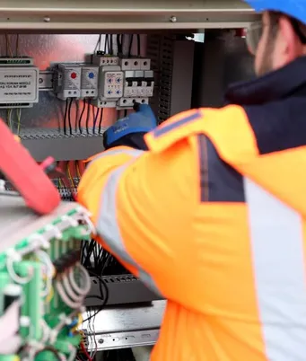 Elektryk pracujący przy instalacji elektrycznej.