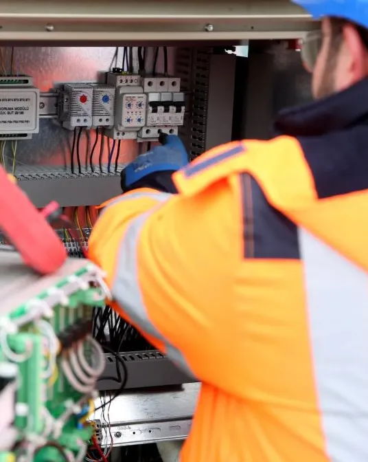Elektryk pracujący przy instalacji elektrycznej.